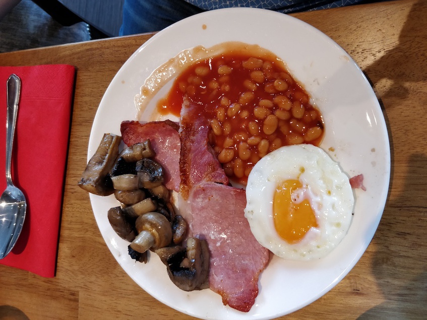 Klassisches Englisches Frühstück: Ei, Speck (sehr lecker), Thomaten, Pilze, Bohnen... es Fehlt das Würstchen (nicht lecker)